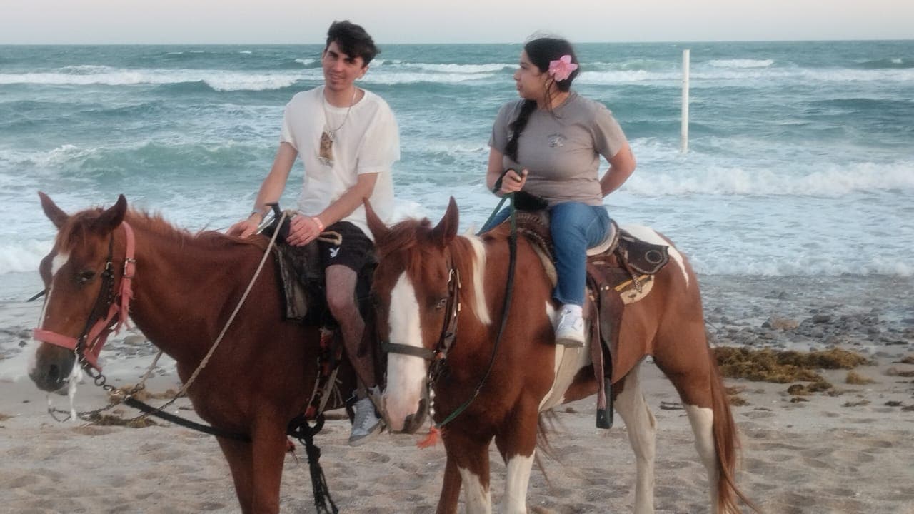 Couple on horseback at the beach